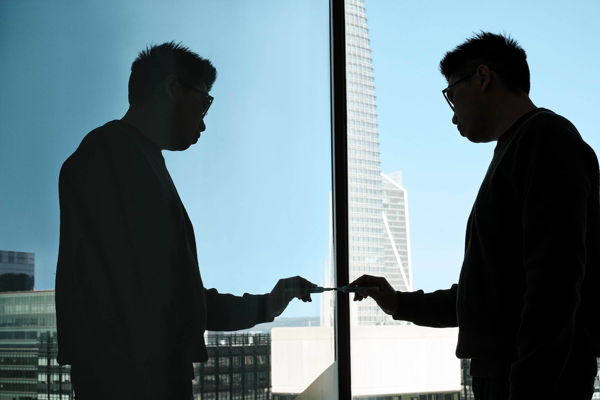 Two Arena team members silhouetted against the San Francisco skyline